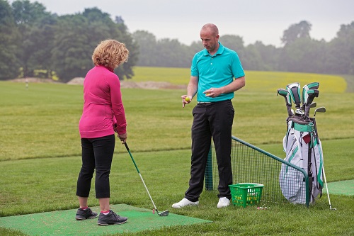 Lady golfer being taught by a golf pro. How to Use a Golf rangefinder Manual Ebook