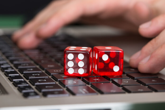 Online gambling. Two dice on the laptop keyboard