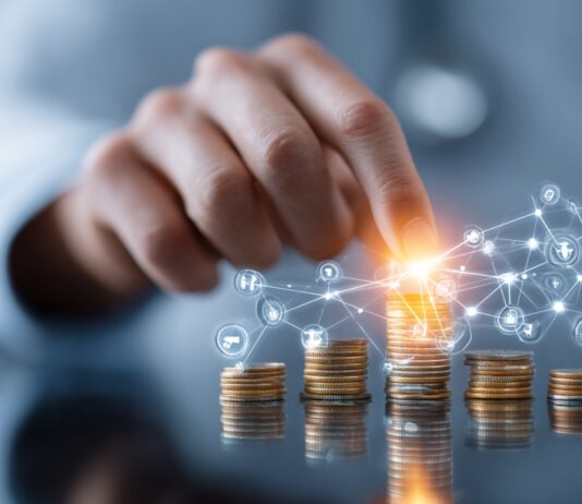 Hand stacking coins with digital network icons representing financial planning and healthcare optimization