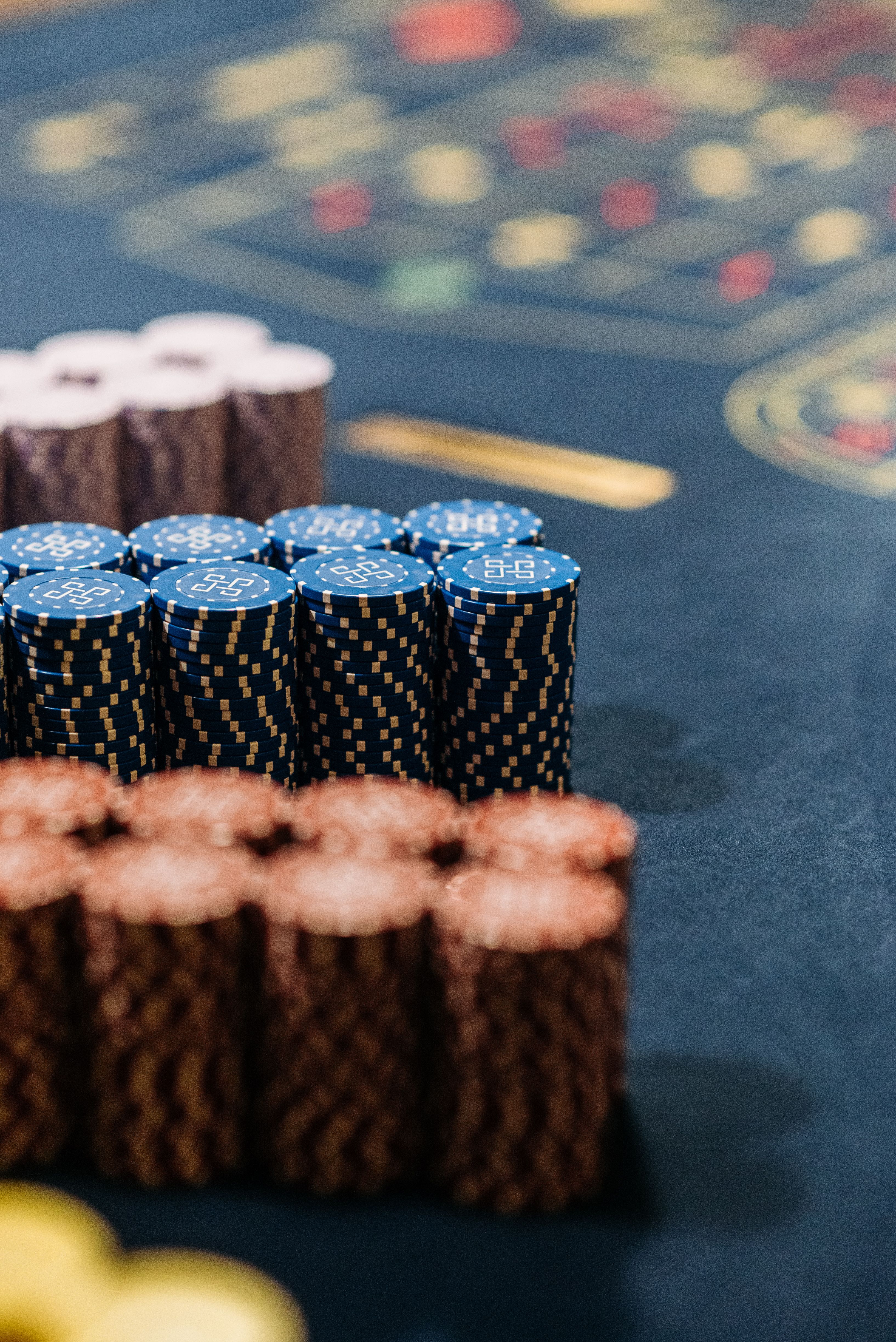 Close-up of colorful stacked casino chips on a roulette table
