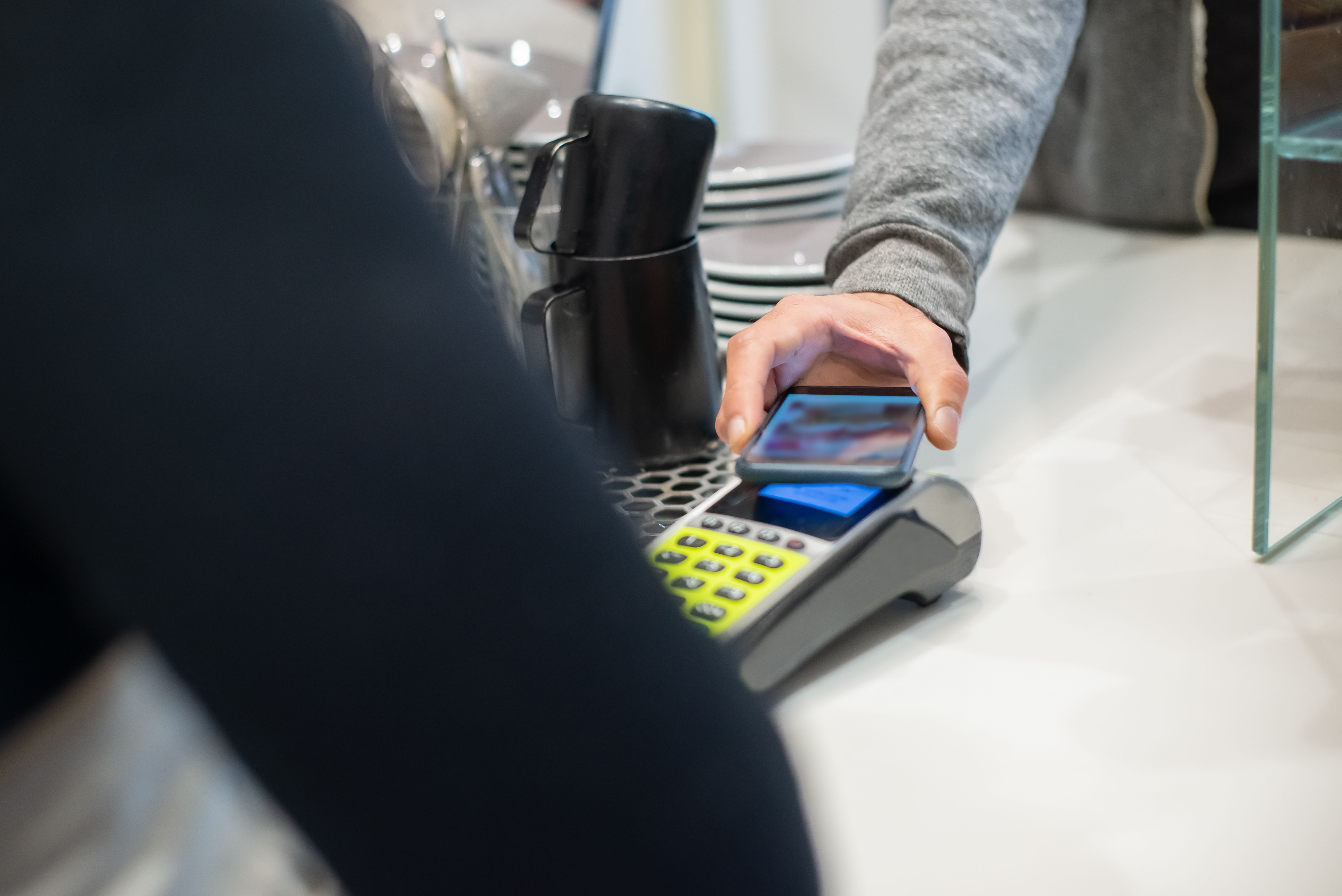 Customer making a contactless smartphone payment, showcasing modern digital transactions