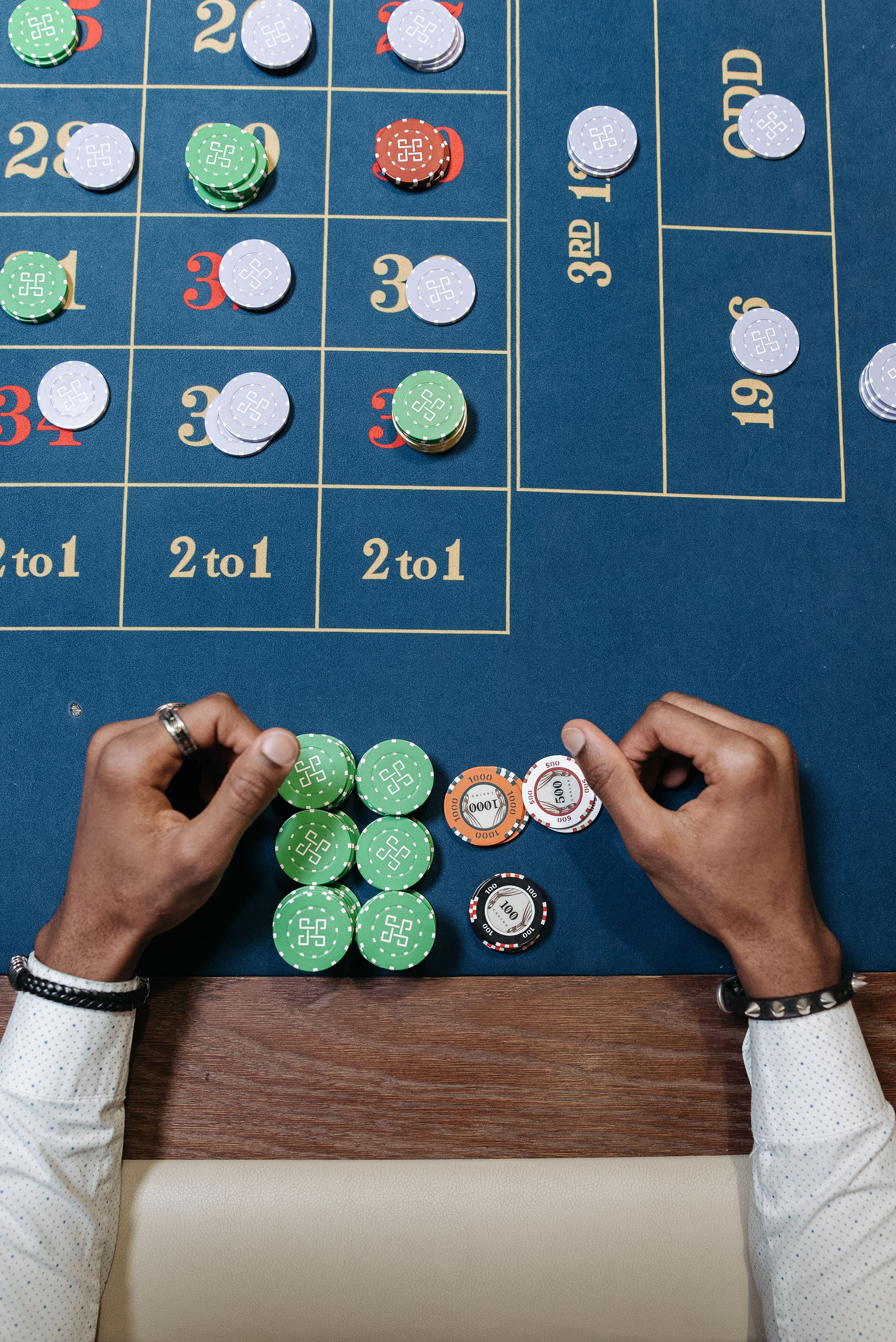Hands arranging casino chips on a betting table