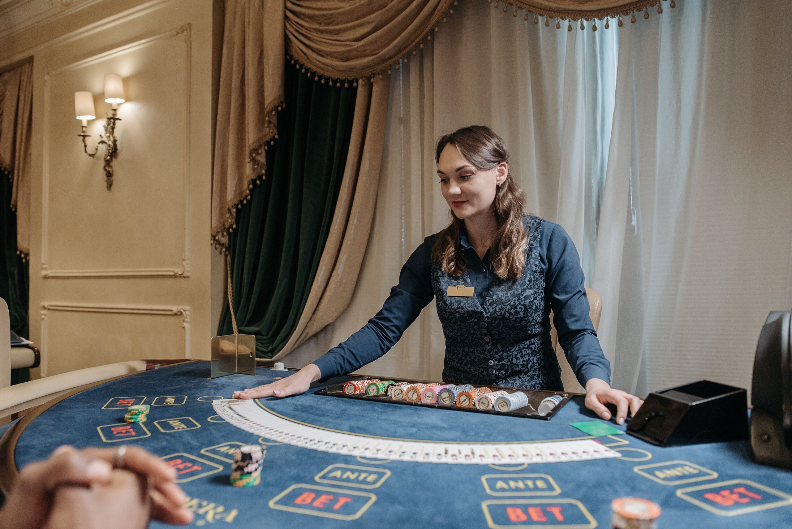 Live Dealer Casino Games: How Streaming Tech Brings Vegas to Your Living Room Casino dealer managing cards and chips in an elegant gambling setting, representing a live dealer casino table
