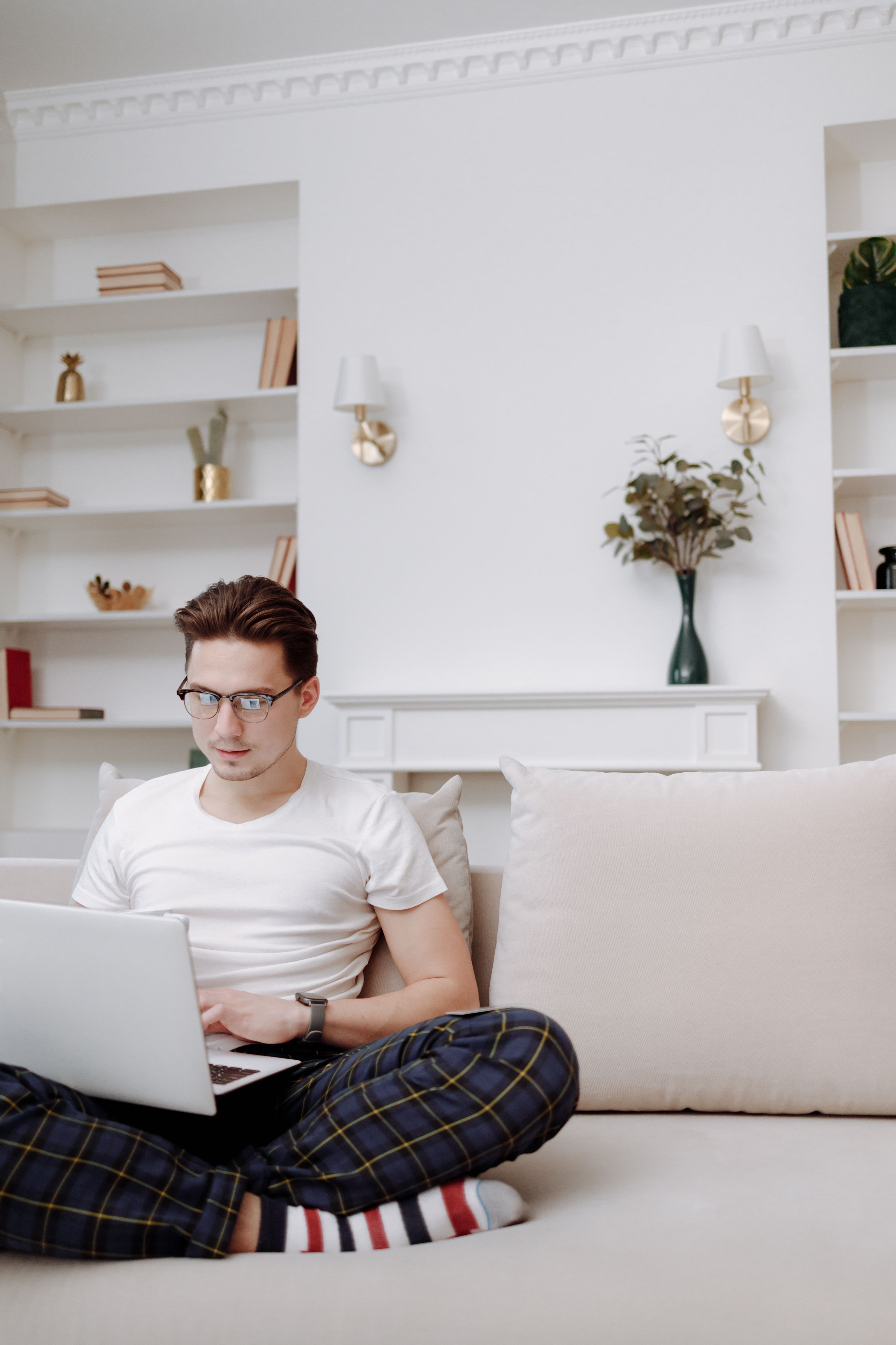 Man relaxing on a couch at home watching a live dealer casino stream on a laptop