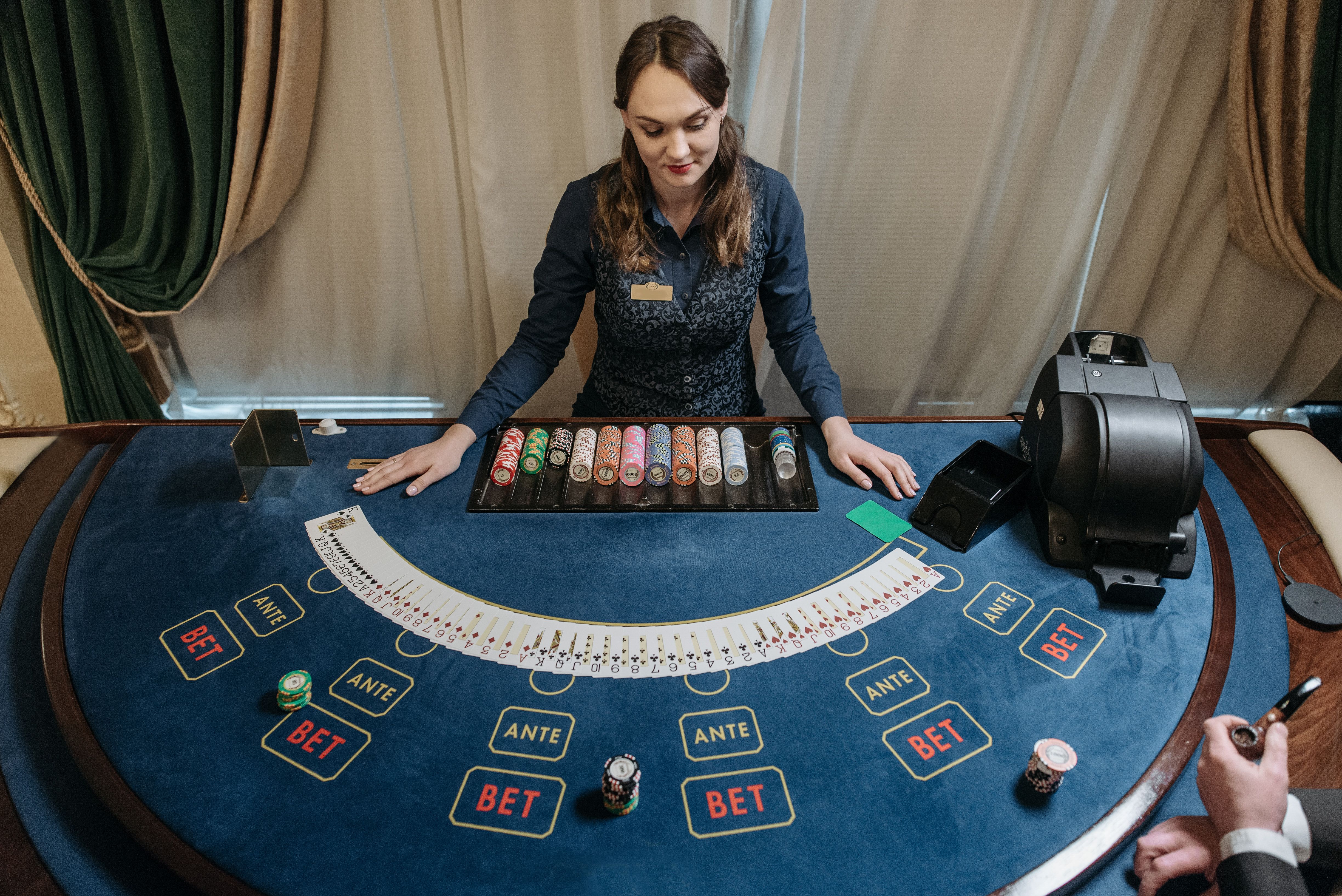 Professional female casino dealer managing a gaming table with chips and cards in a luxurious live dealer studio