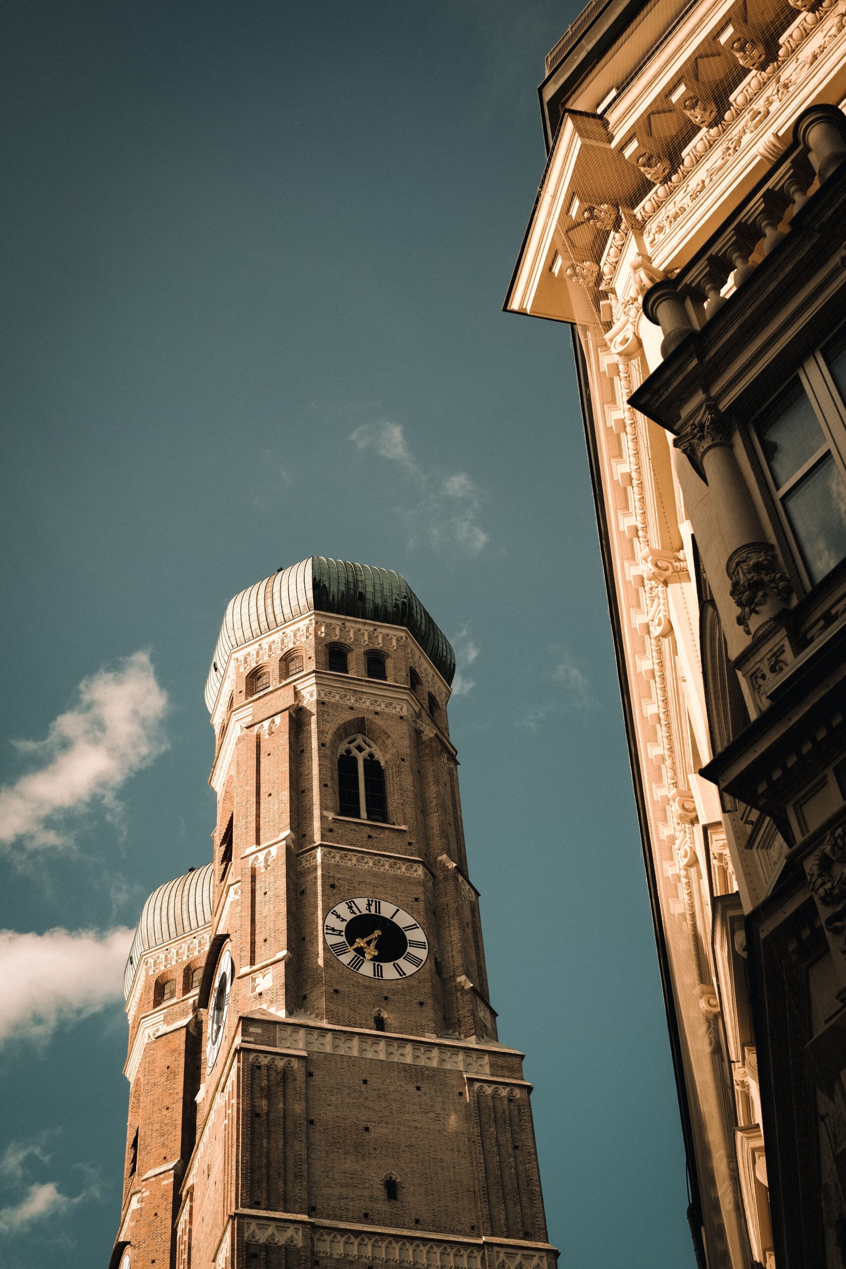 Low angle view of the iconic Frauenkirche tower in Munich showcasing gothic architecture and urban skyline