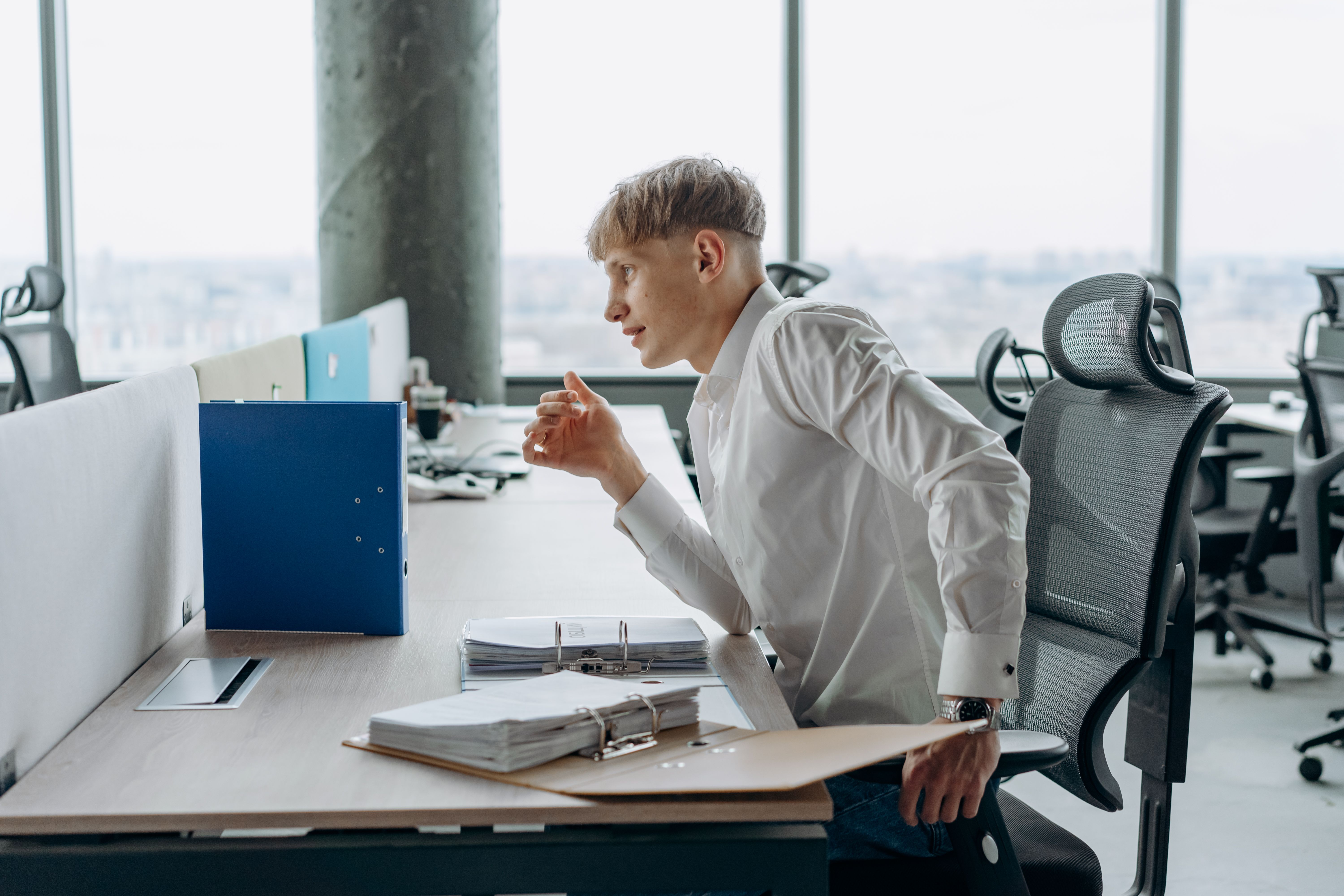 Man sitting at an office desk in poor posture, a common cause of recurring back pain