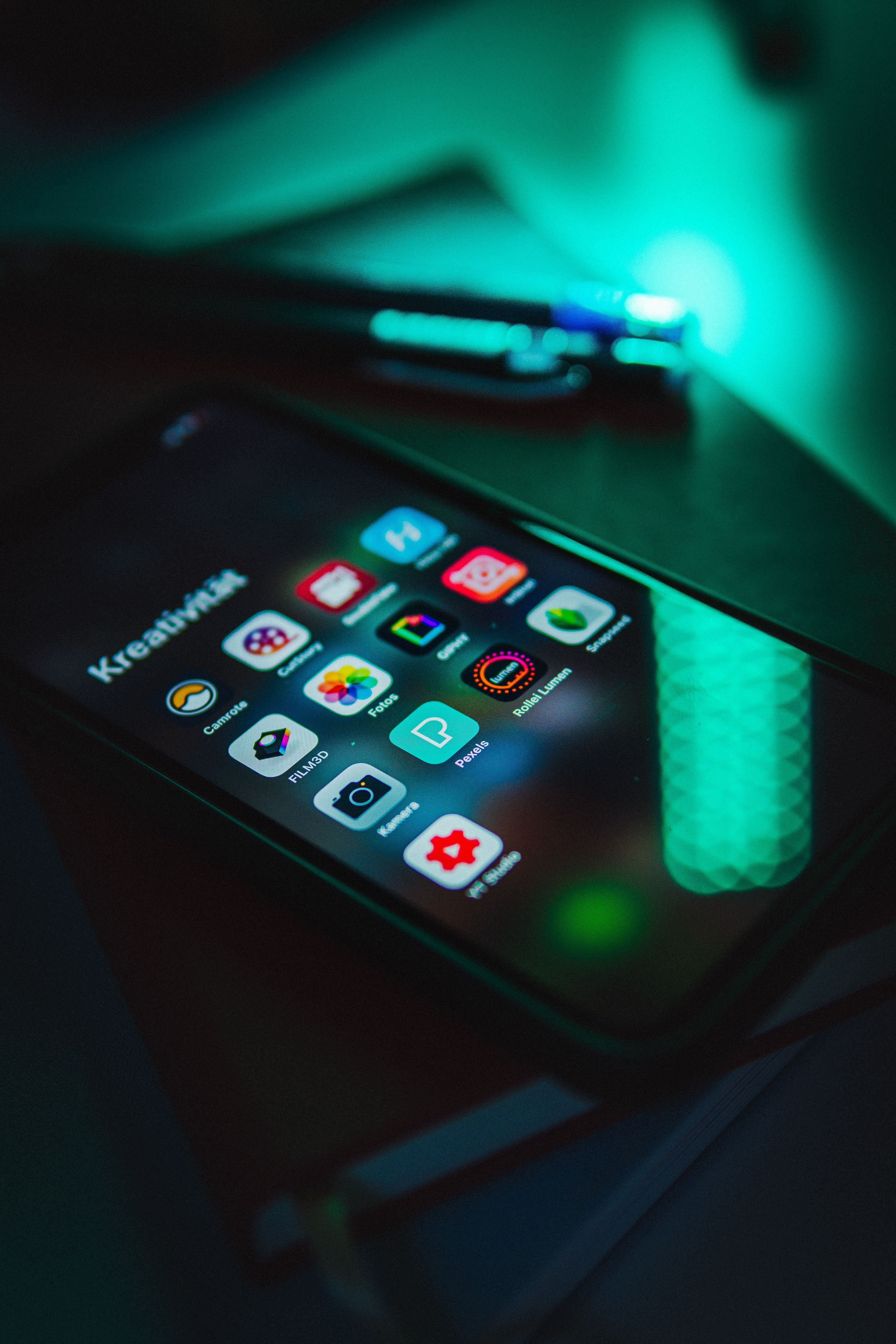 Smartphone screen glowing with colorful app icons in low light, representing online betting apps