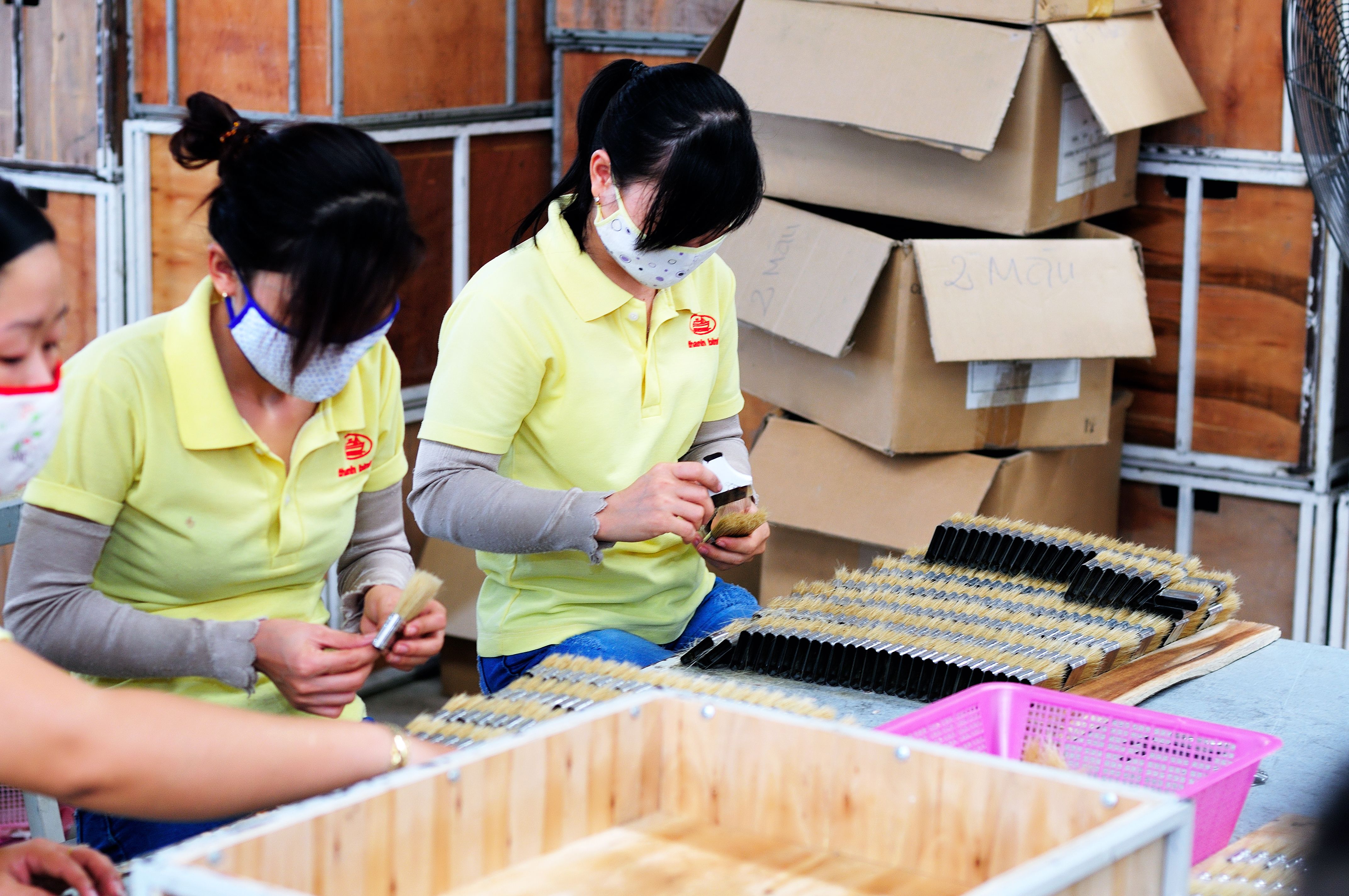 Factory workers assembling and packaging products on a production line