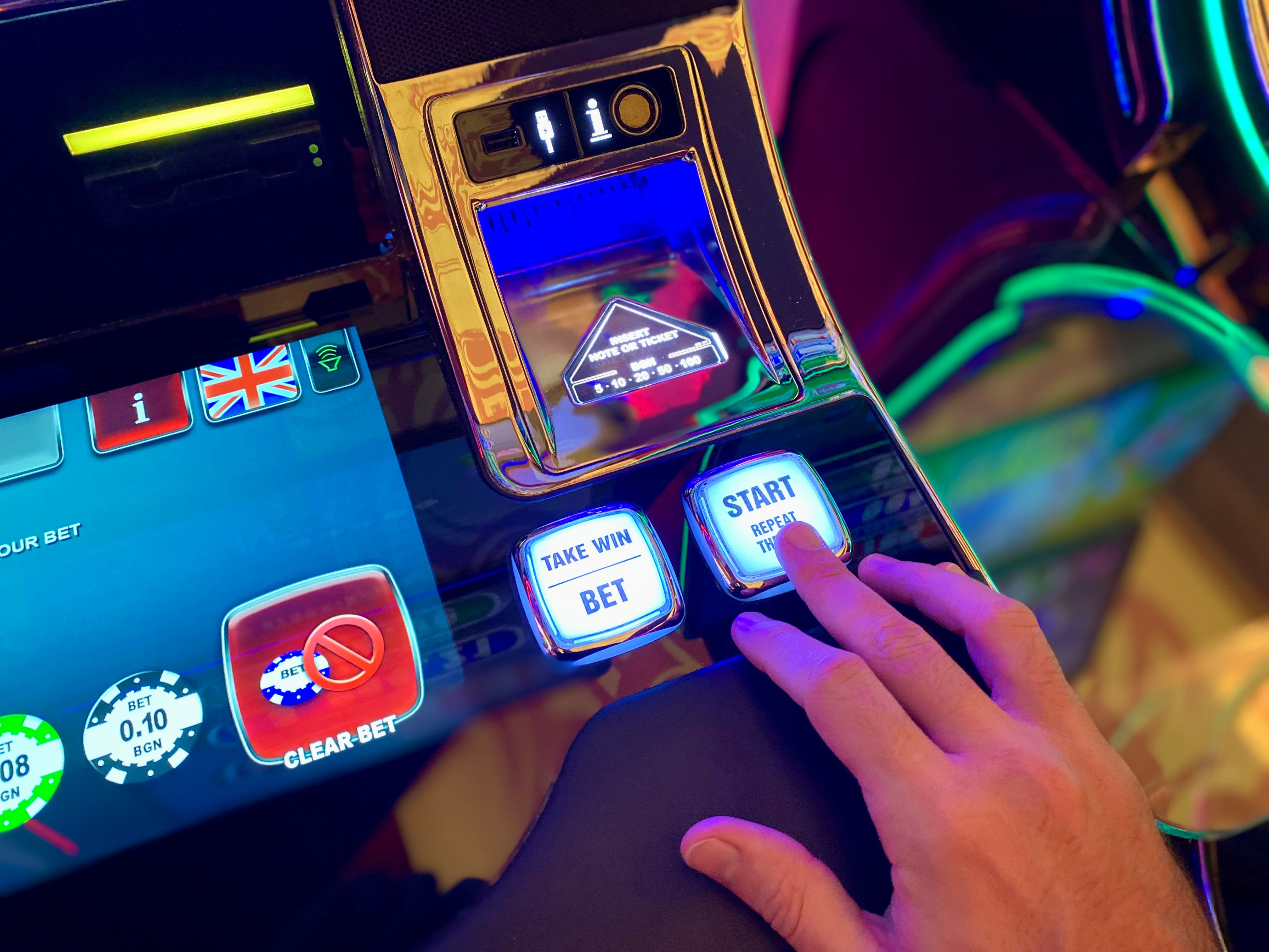Hand tapping a colorful slot machine interface, showing a clear and interactive casino game control.