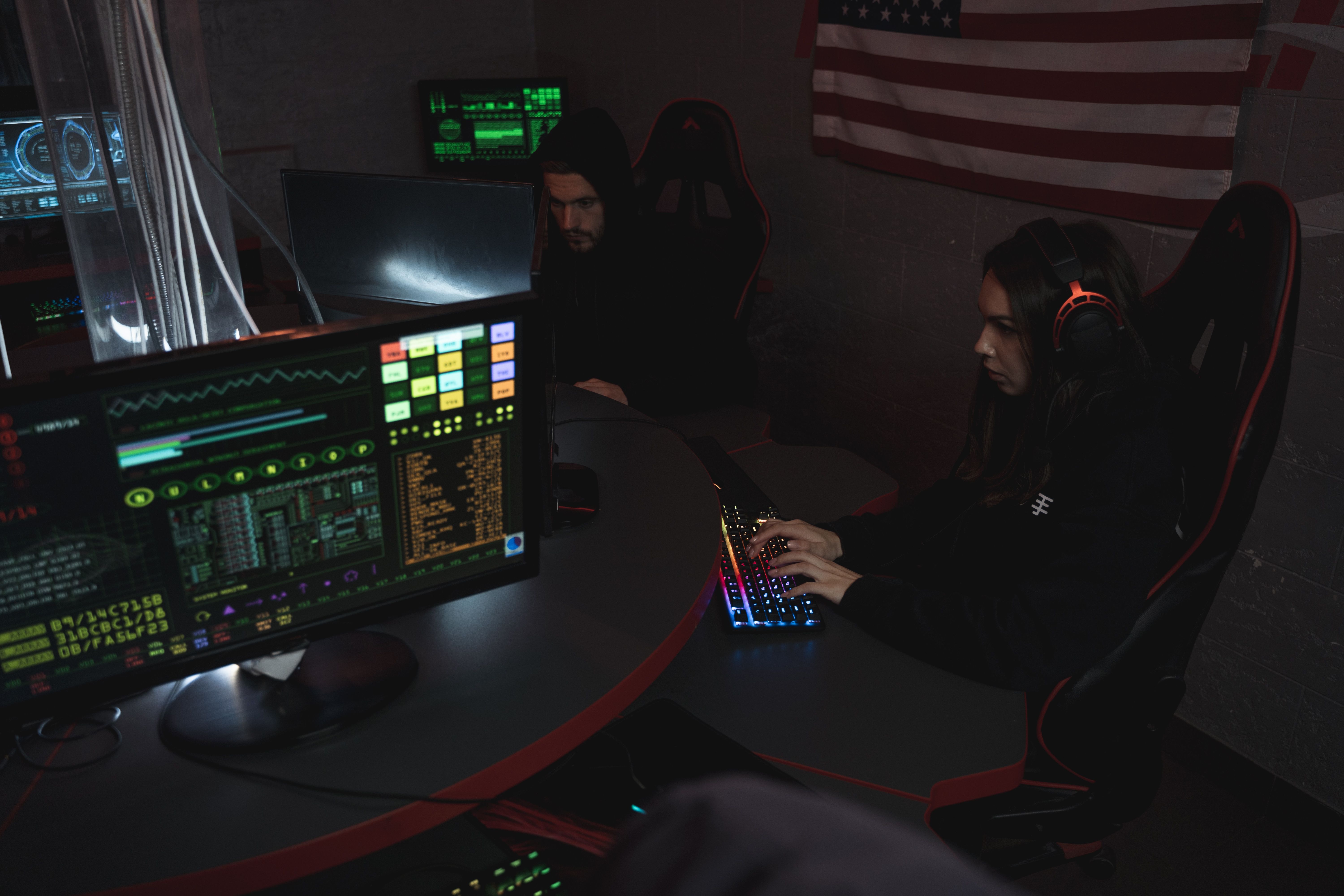 Cybersecurity professionals working together at computer systems for coordinated defensive analysis.