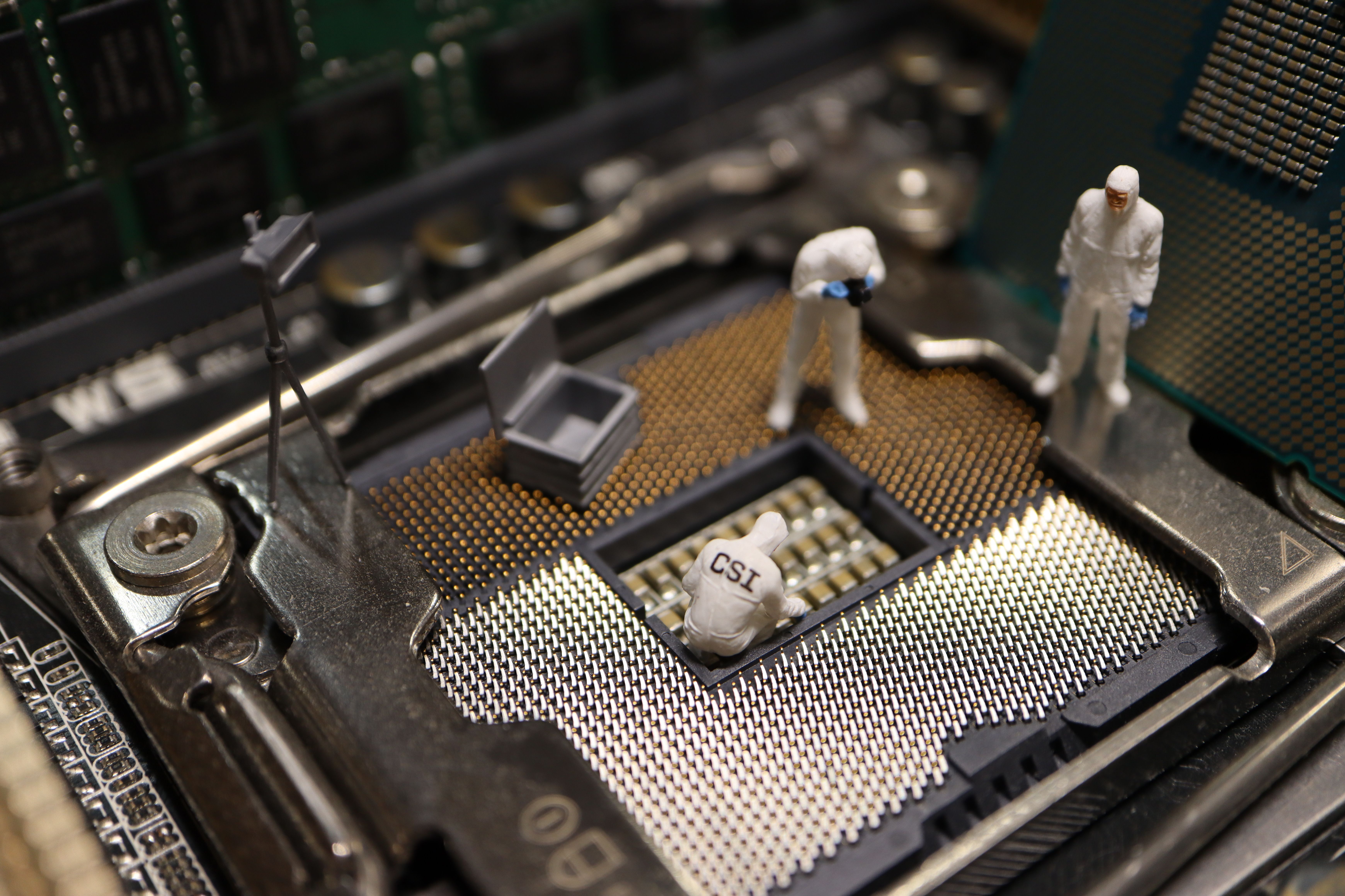 Miniature investigators examining a computer processor, representing digital forensics and attacker attribution.